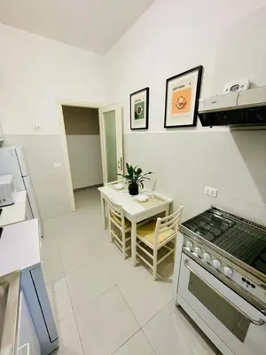 a kitchen with a table and a stove top oven at La Casa di Giada in Rome