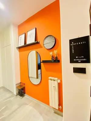 an orange wall in a bathroom with a mirror at La Casa di Giada in Rome
