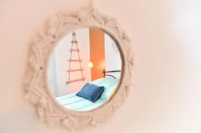 a mirror reflecting a room with a chair and a ladder at Nest house in Rome
