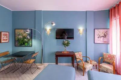 a dining room with blue walls and a table and chairs at Tu chiamale emozioni intero appartamento in Rome