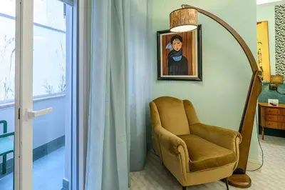 a room with a chair and a painting on the wall at Tu chiamale emozioni intero appartamento in Rome