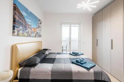 a bedroom with a bed in a white room at Private Parking - Bilocale Monti Tiburtini in Rome