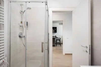 a shower with a glass door in a bathroom at Private Parking - Bilocale Monti Tiburtini in Rome