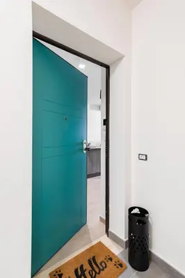 a green door in a room with a rug at Private Parking - Bilocale Monti Tiburtini in Rome