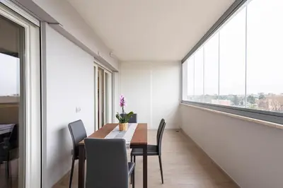 a dining room with a table and chairs and a large window at Private Parking - Bilocale Monti Tiburtini in Rome