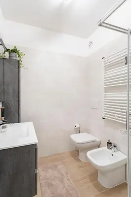 a white bathroom with a sink and a toilet at Private Parking - Bilocale Monti Tiburtini in Rome
