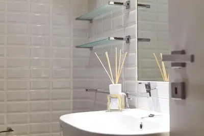 a white bathroom with a sink and a mirror at Piazza Cancelleria in Rome