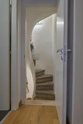 a hallway with a stairway leading up to a room with white walls at Piazza Cancelleria in Rome