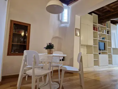 a dining room with a table and white chairs at Piazza Cancelleria in Rome