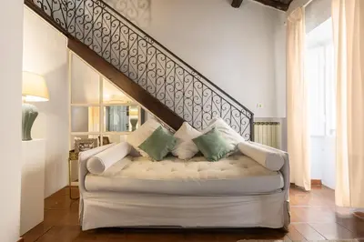 a living room with a white couch with pillows at Piazza Navona Loft for 7 people in Rome