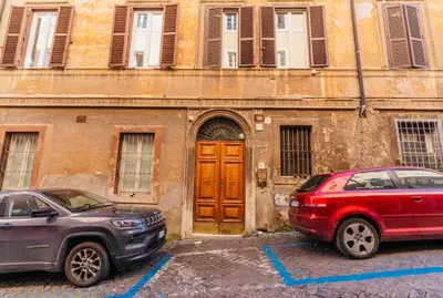two cars parked in front of a building with a wooden door at Rome at Home in Rome