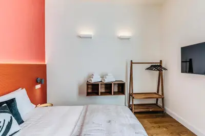 a bedroom with a bed and a mirror and a chair at Rome at Home in Rome