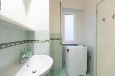 a bathroom with a toilet and a sink and a window at Trastevere Relax by Rental in Rome in Rome