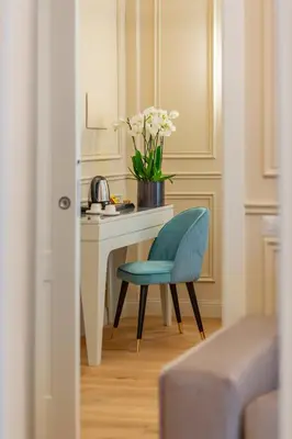 a desk with a blue chair and a vase of flowers at Trevi Imperial Suite 3 in Rome