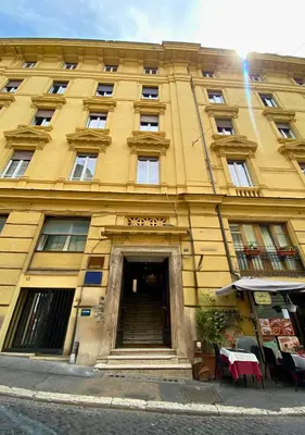 a large yellow building with a table in front of it at Trevi Imperial Suite 2 in Rome
