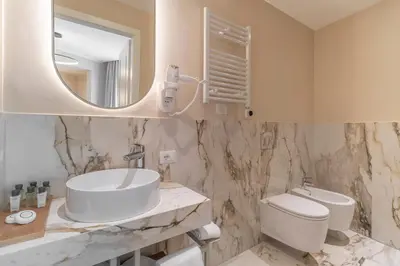 a bathroom with a sink and a toilet and a mirror at Trevi Imperial Suite 1 in Rome