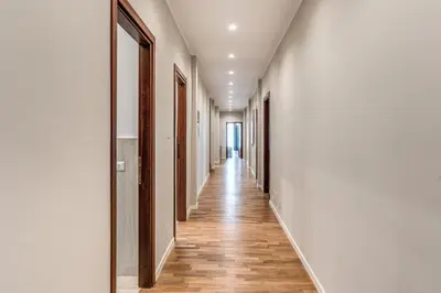 a hallway with white walls and wooden floors at DOWNTOWN SRL - The Great Court and The Great Chill in Rome
