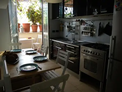 a kitchen with a wooden table and a stove top oven at Esquilino Piano Alto in Rome