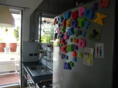a refrigerator covered in magnets in a kitchen at Esquilino Piano Alto in Rome