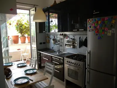 a kitchen with a table and a refrigerator at Esquilino Piano Alto in Rome