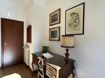 an office with a desk with a lamp and pictures on the wall at Feel at home in Rome