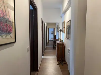 a hallway with white walls and wooden floors and a hallway with doors at Feel at home in Rome