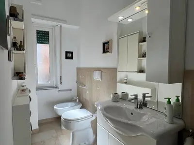 a white bathroom with a toilet and a sink at Feel at home in Rome