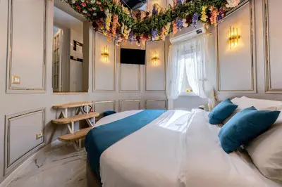 a bedroom with a large bed with blue pillows at Flowers' Circle of piazza di Spagna in Rome