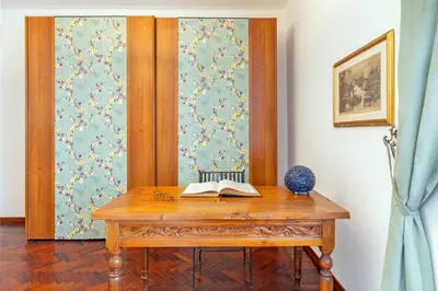 a white bedroom with a bed and a table at la casa dell'agrumeto in Rome