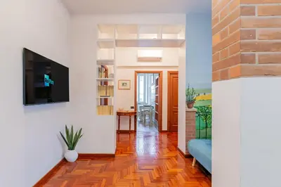 a living room with a couch and a tv on a wall at la casa dell'agrumeto in Rome