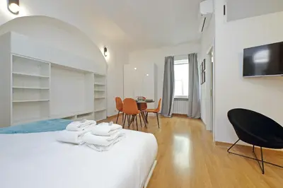 a white room with a bed and a table and chairs at Modern flat in Termini Station in Rome