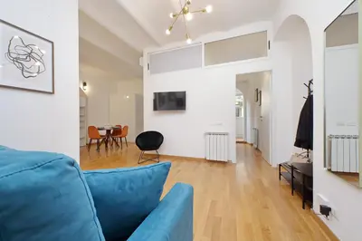 a living room with a blue couch and a dining room at Modern flat in Termini Station in Rome