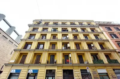 a tall yellow building with a lot of windows at Modern flat in Termini Station in Rome