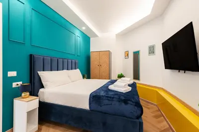 a bedroom with a bed with a blue wall at Casa Vacanze Ourplaces Sacchetti in Rome