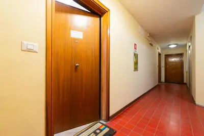 a hallway with a wooden door and a tile floor at Casa Vacanze Ourplaces Sacchetti in Rome