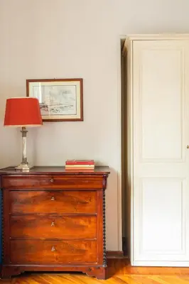 a lamp on top of a dresser next to a door at Casa Augusta, a Burghesius home in Rome