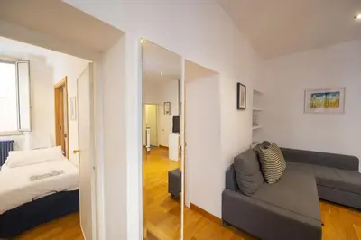 a room with a couch and a bed and a mirror at Cozy 2BR Apartment near Piazza Navona in Rome