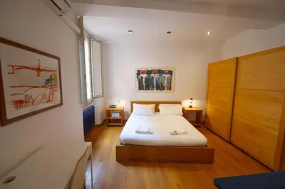 a bedroom with a bed and a wooden cabinet at Cozy 2BR Apartment near Piazza Navona in Rome