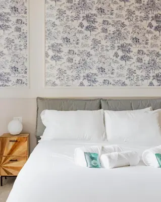 a bedroom with a white bed with a floral wallpaper at Loft Piazza Vittorio - Zen 38 in Rome