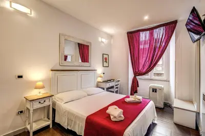 a bedroom with a bed with a red blanket at GuestHouse o Affittacamere La civetta di Trastevere in Rome
