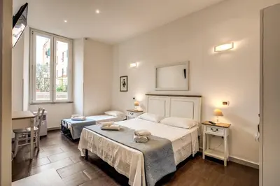 a bedroom with two beds and a table in it at GuestHouse o Affittacamere La civetta di Trastevere in Rome