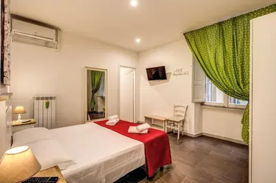 a bedroom with a bed with a red blanket at GuestHouse o Affittacamere La civetta di Trastevere in Rome