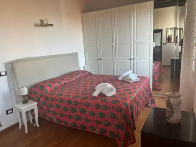 a bedroom with a red bed with two towels on it at Trastevere Penthouse amazing terrace in Rome
