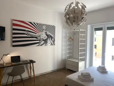 a room with a bed and a desk and a painting at Clodio Apartment in Rome