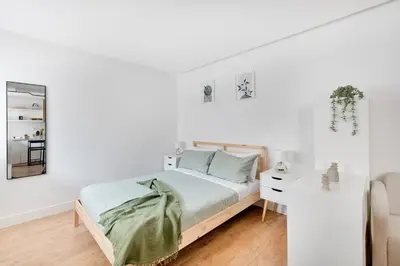 a white bedroom with a bed and a desk at NOH Vatican Studio in Rome