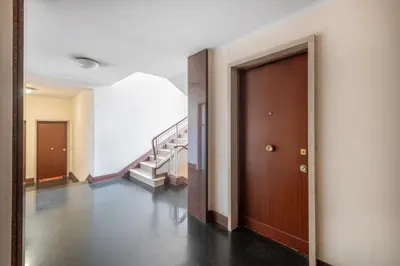 a hallway with a wooden door and stairs at NOH Vatican Studio in Rome