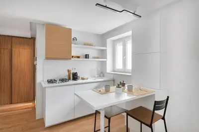 a white kitchen with a white table and chairs at NOH Vatican Studio in Rome