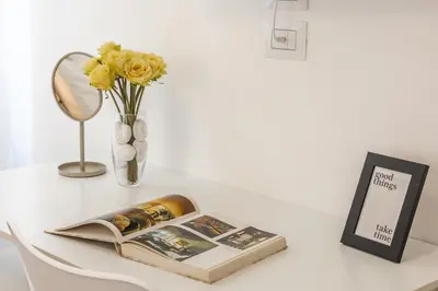 a table with a book and a vase with yellow flowers at Vaticano Domvs - Appartamento ai Musei Vaticani in Rome