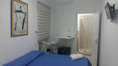 a bedroom with a blue bed and a mirror at Guest House San Pietro in Rome