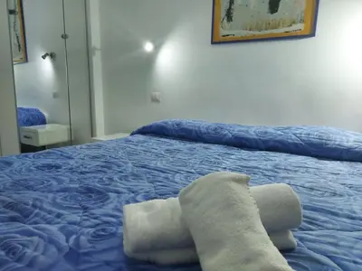 a bedroom with a blue bed with towels on it at Guest House San Pietro in Rome